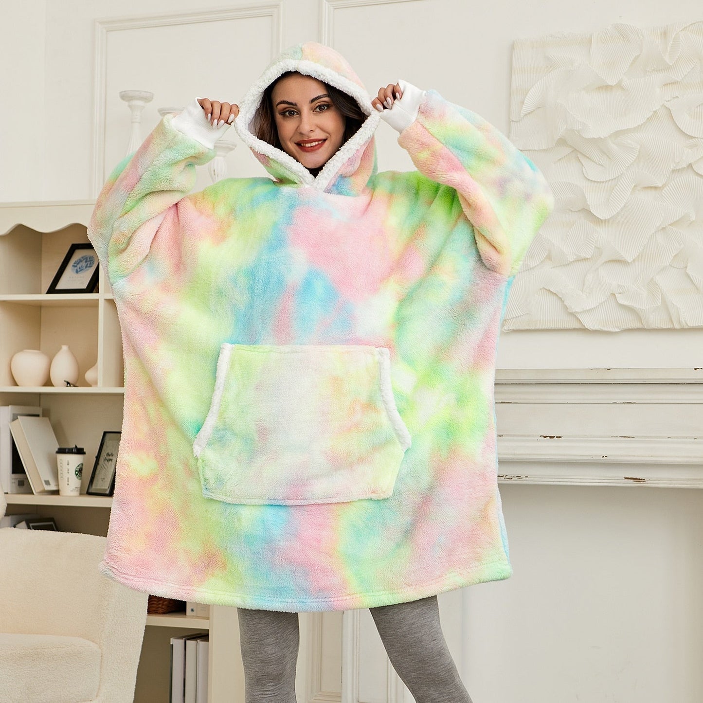 Frau in buntem, übergroßem Hoodie-Decke, Kapuze, gemütlich, Wohnzimmer, Mode, Freizeitkleidung.